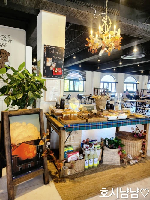 팔당 윈터포레스트1224 디저트존 &ndash; 샹들리에 조명 아래 다양한 빵과 쿠키가 진열된 감성 베이커리 공간