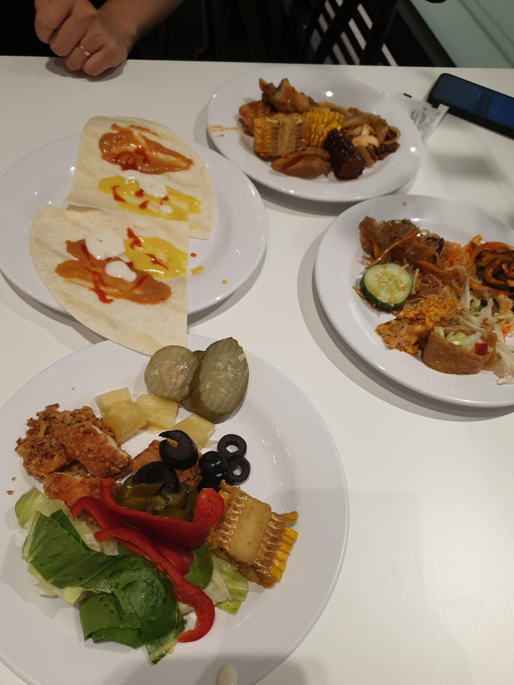 토르티아 및 각종 음식물, 접시 4개가 보인다.