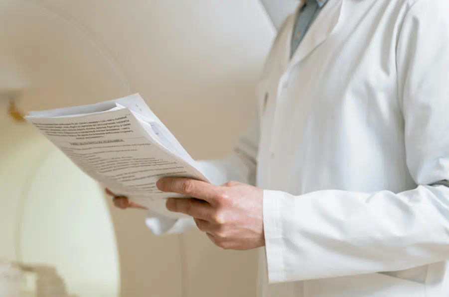 한 남성 의사가 건강검진서류를 체크하면서 읽고있다