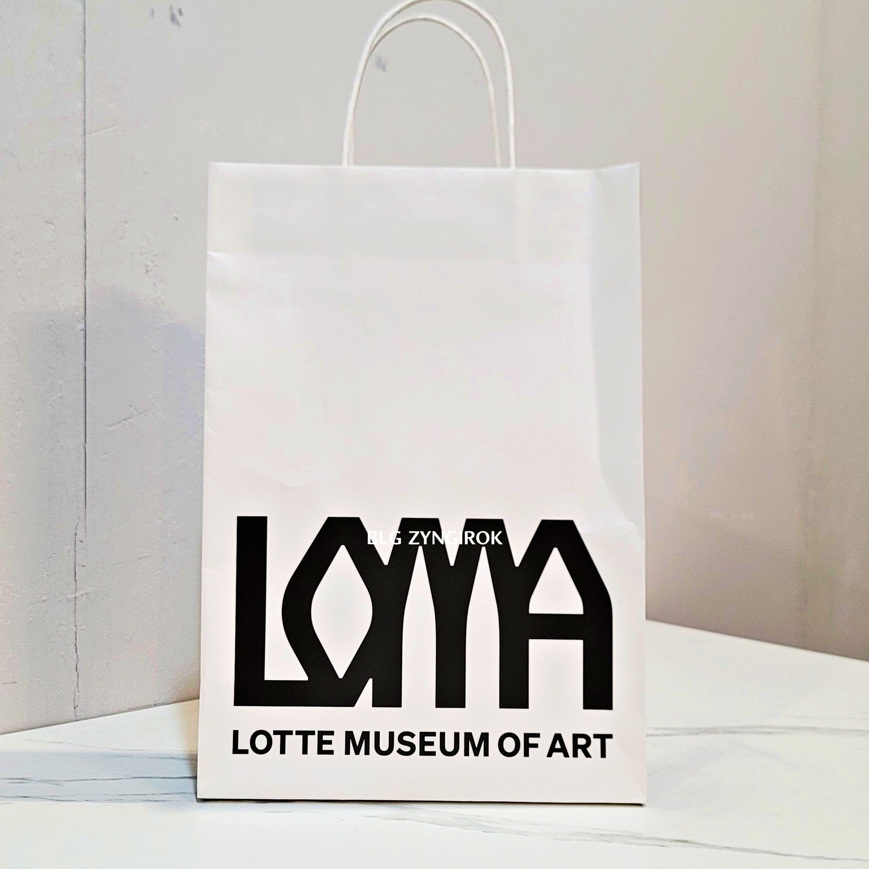 롯데타워 - 롯데뮤지엄 고혹의 보석 매혹의 시간 - 도록과 기념품을 구매한 종이가방이 테이블 위에 놓여있다.