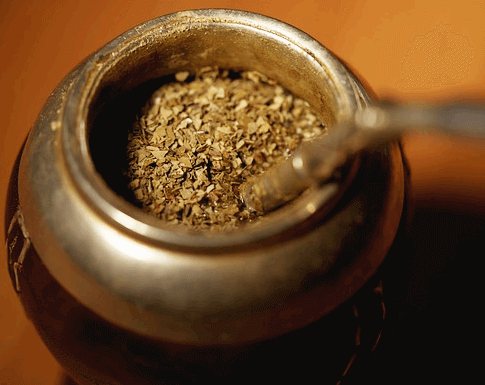 쇠로 만든 고동색 차 그릇에 갈색의 마테차 가루가 한가득 들어 있다.