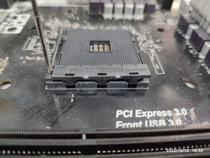 고장난 메인보드의 AM4 소켓 커버를 열어보고 있습니다