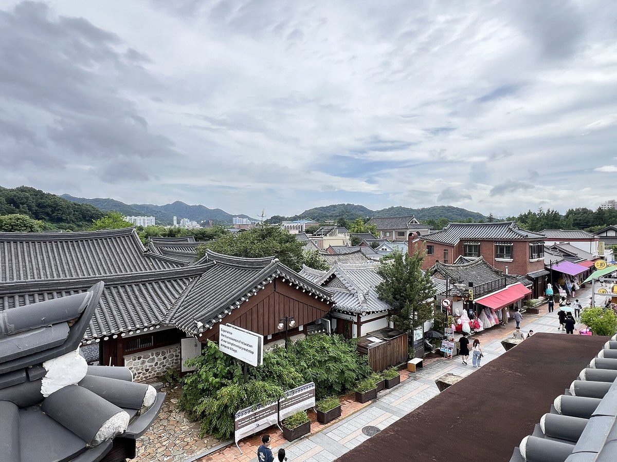 Looking down a lane of tiled hanok shops in Jeonju Hanok Village on a cloudy day