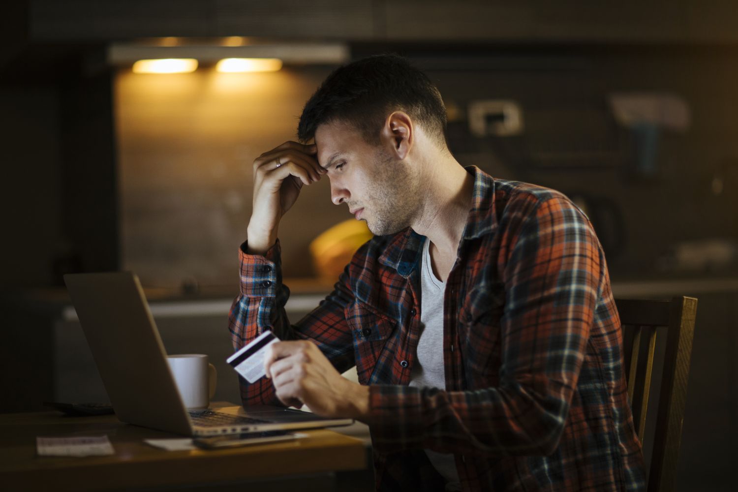 카드로 결제한 뒤 지출 내역을 확인하며 고민하는 남성의 모습, 생활비와 카드값 부담 상황