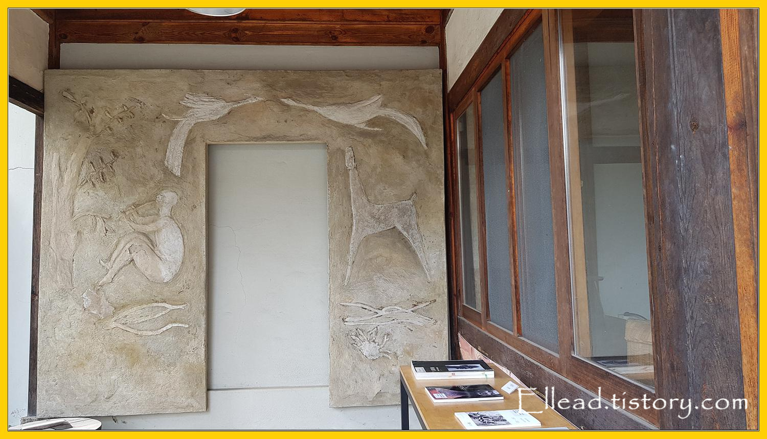 툇마루 위, 그리고 벽면에 그가 만든 부조가 보인다.