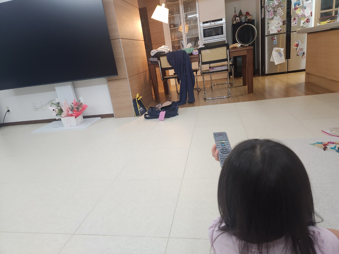 딸이 리모컨으로 영어 영상 틀려고 하는 모습