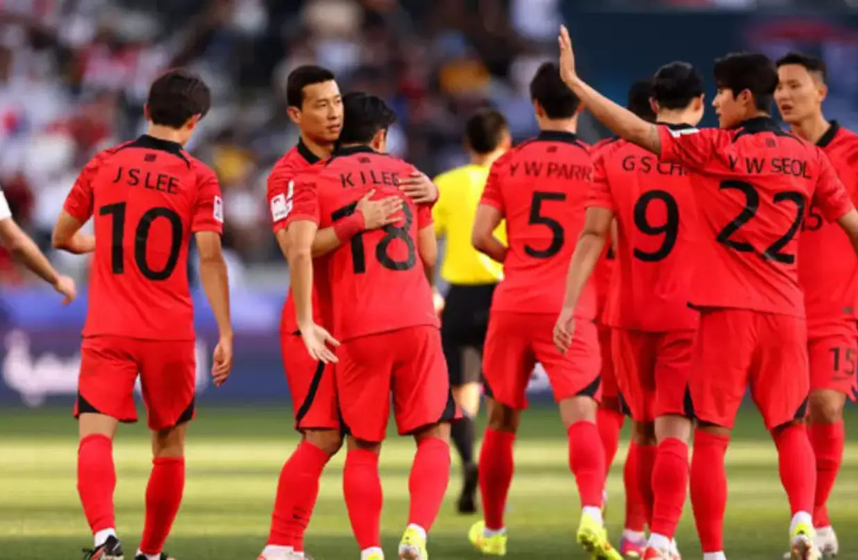 붉은 유니폼을 입고 서로 안고있는 대표팀 선수들