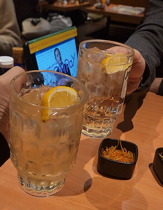 레몬이 올려져 있는 하이볼로 건배하는 모습