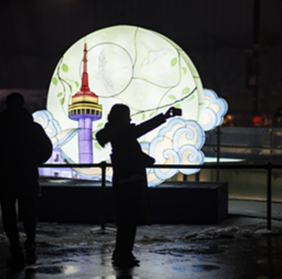빛을 배경으로 사진을 찍고 있는 여성