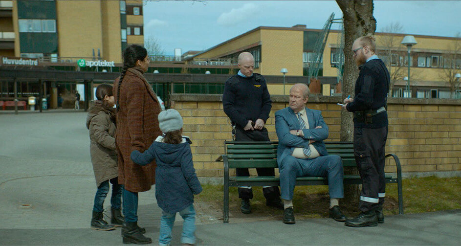 벤치에 앉아있는 오베와 이웃 주민 파르바네 가족들