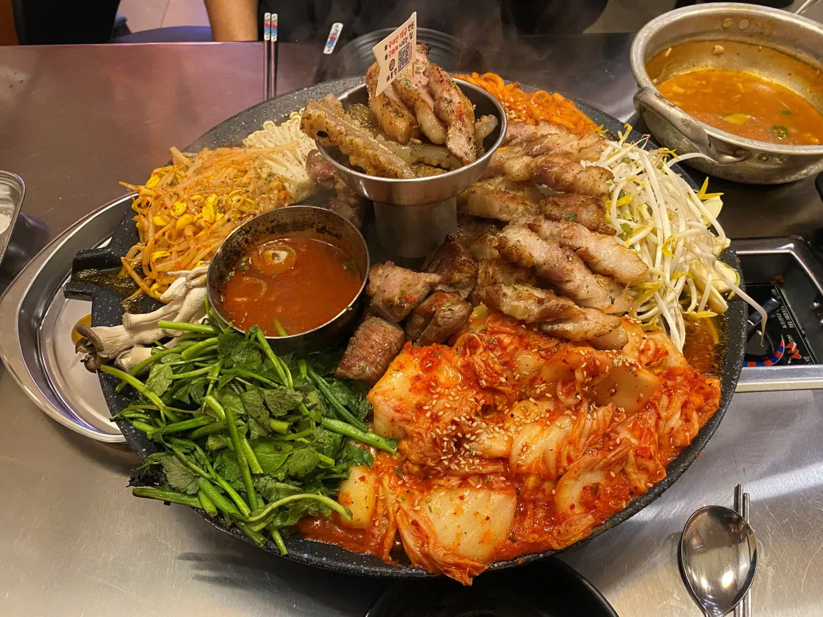 솥뚜껑-위에-올려진-고기와-채소들