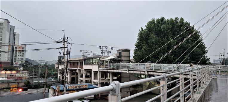 석수역으로 가는 고가육교, 왼쪽엔 아파트 건물, 석수역 뒤에 큰 나무,