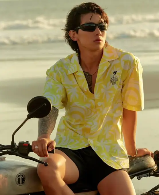 솔로지옥3-
검은색 오토바이 위 반바지에 노란색 꽃무늬 반팔셔츠를 입고 선글라스를 낀채 먼곳을 바라보는 덱스