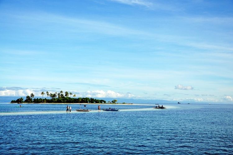 : 작은 열대 섬과 샌드바 위를 걷는 여행자들 모습