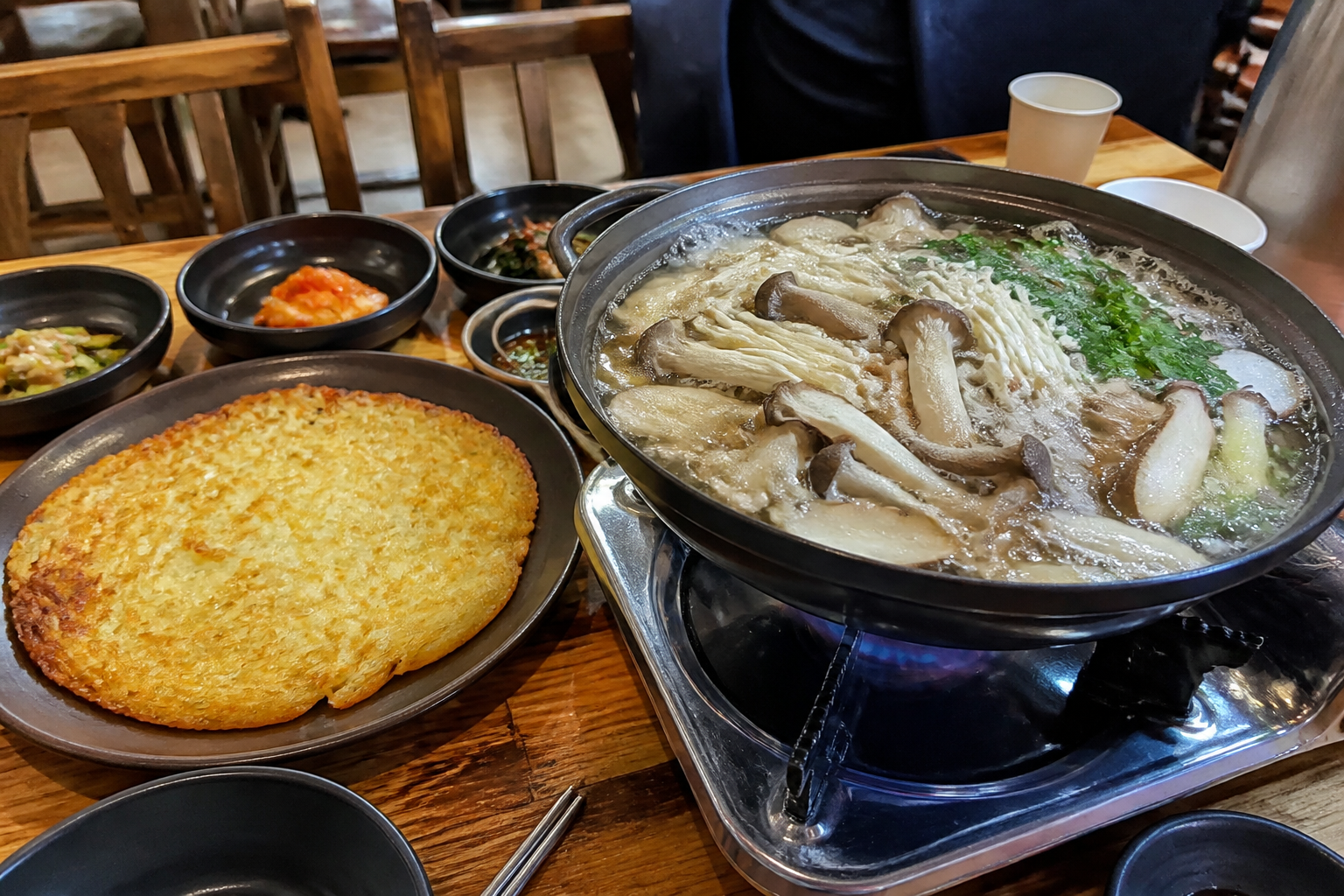 여러 버섯이 담긴 전골과 노릇하게 구운 감자전