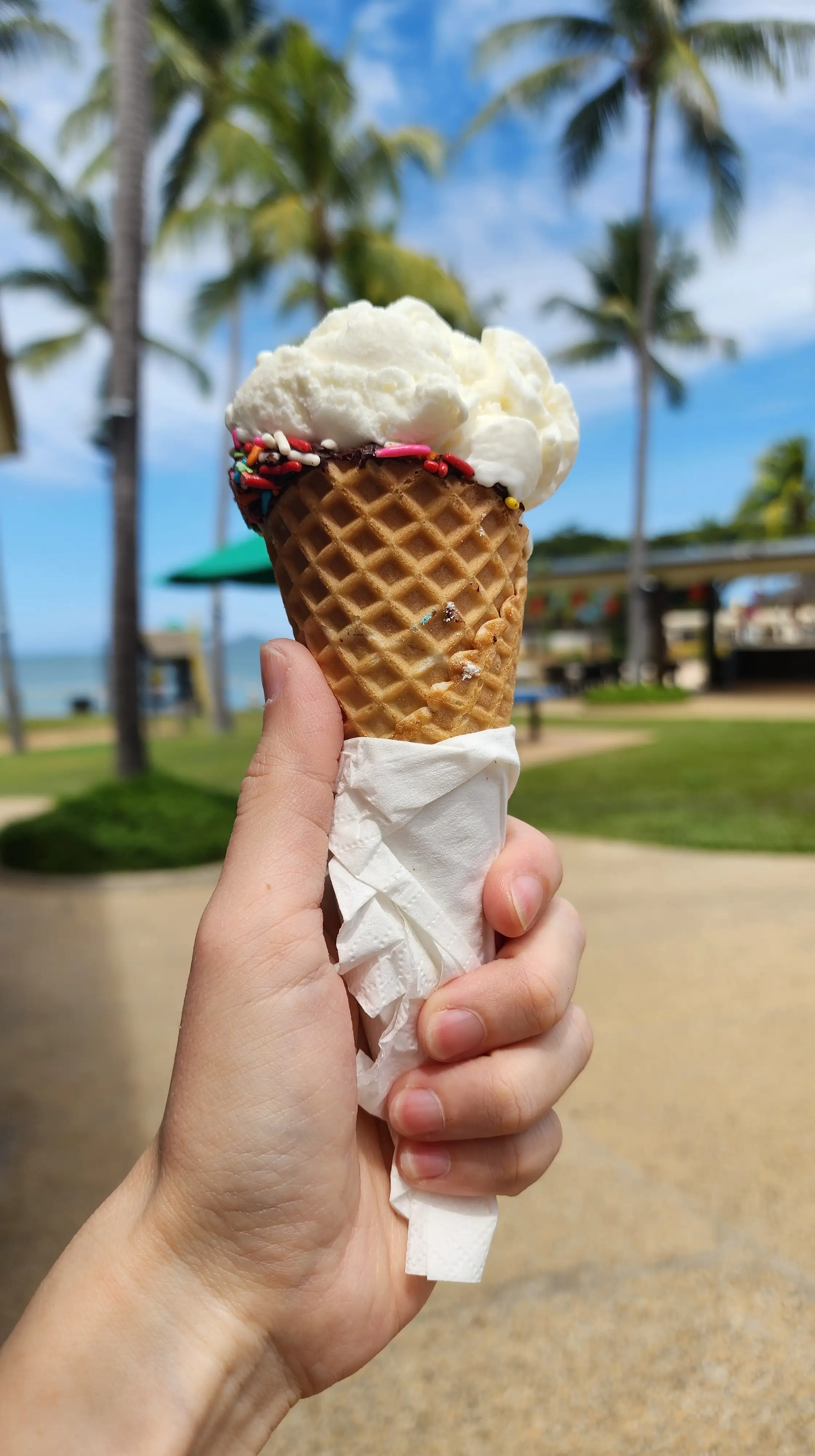 한-손으로-아이스크림을-들고있고-뒷쪽으로는-야자수와-바다가보이는-사진-02