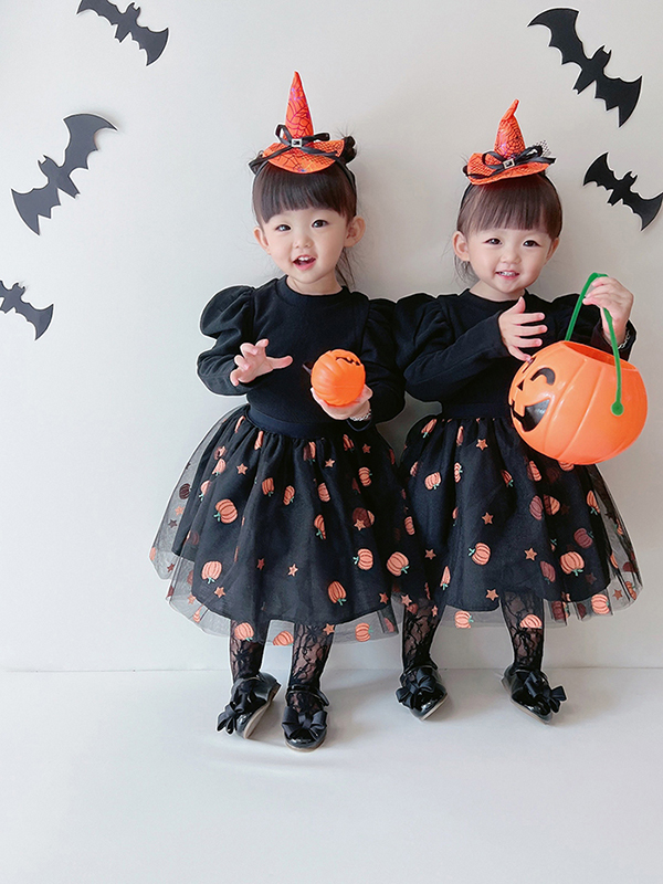 할로윈 의상으로 포즈 취하는 쌍둥이