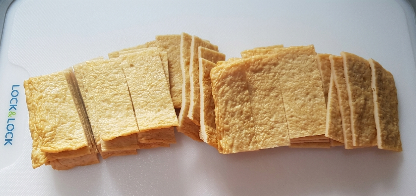 도마 위에 가지런히 놓인 얇게 썬 어묵.