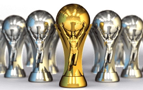 축구공 모양을 가진 축구 대회 트로피 5개가 있다. 가운데는 골드 우숭컵이 있고 양 옆에는 2개씩 은색 컵들이 있다.