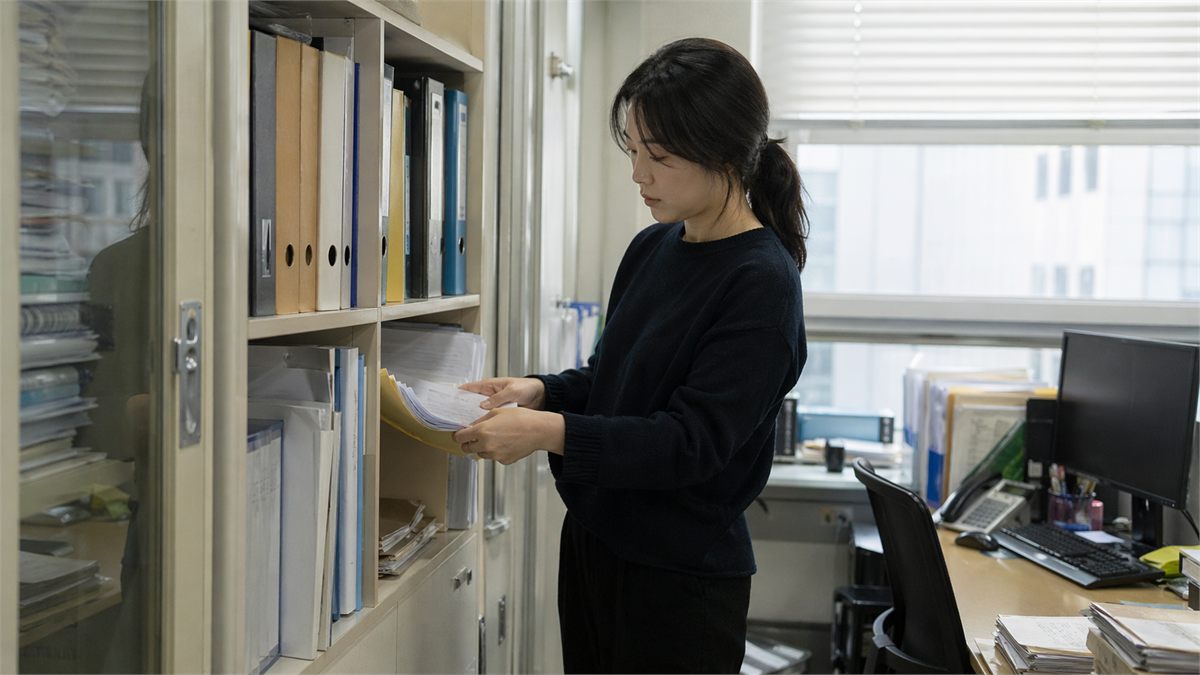 사무실에서 경력 증명 관련 서류를 정리하는 한국인 여성 모습