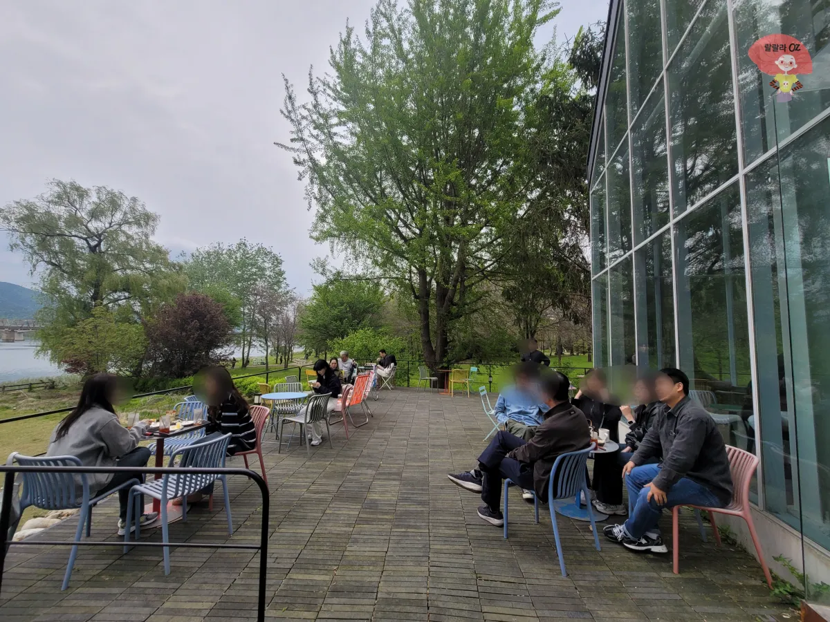경기-양평-북한강뷰-쌀베이커리카페-그림정원-외부-테라스-테이블에-앉은-사람들