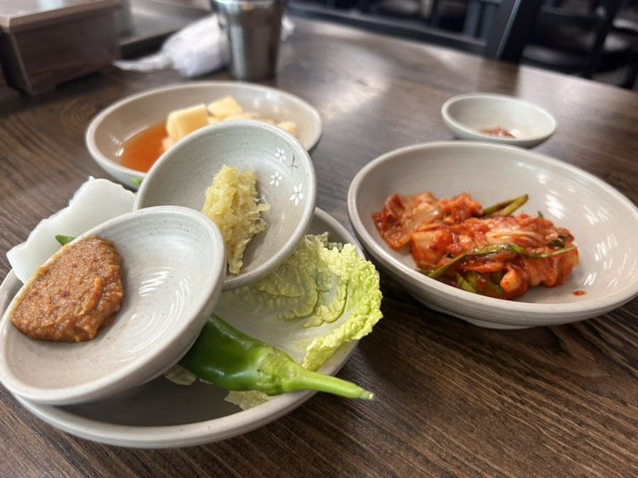 은희네해장국 함덕점에서 제공되는 기본 반찬으로 신선한 쌈채소와 김치, 깍두기가 정갈하게 차려진 모습.