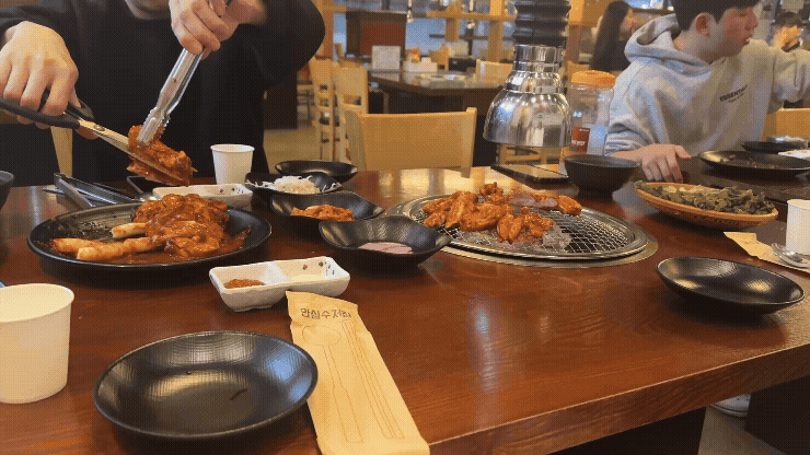 칠오닭갈비 양평서종점에서 양념닭갈비를 숯불 위에 올려 굽는 장면, 연기가 솔솔 피어오르는 모습
