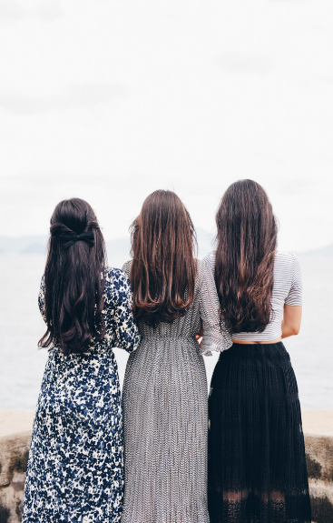 허리까지 내려오는 건강한 머릿결을 갖고 있는 세명의 여성의 뒷모습 사진