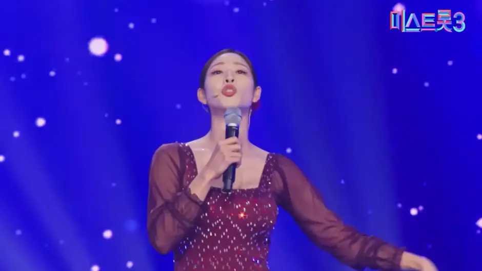 미스트롯3- 불은색 망사드레스를 입고 오른손으로 마이크를 올린채 관중을보고 노래하는 신수지