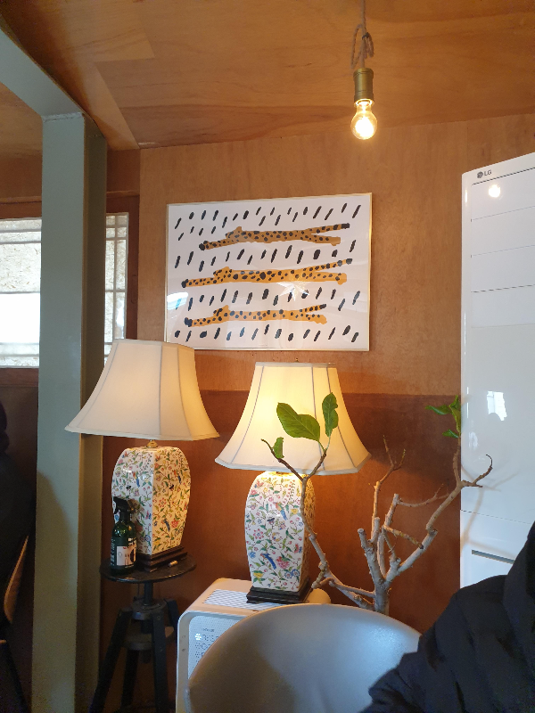 표범이 그려진 액자 아래 도자기 스탠드 조명이 2개 있다.