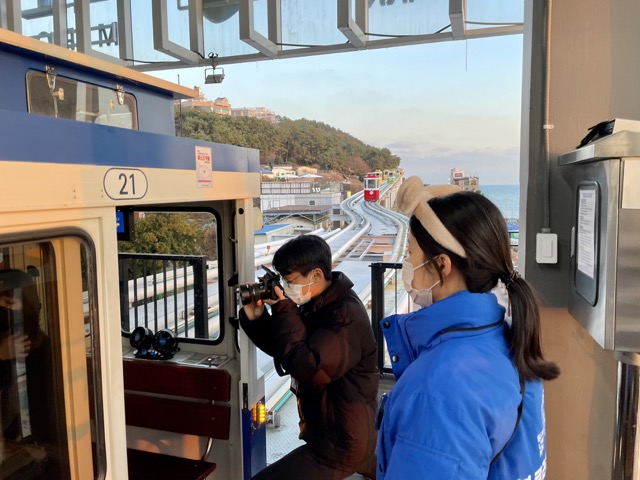 해운대-블루라인파크-스카이캡슐-직원들이-사진을-찍어준다