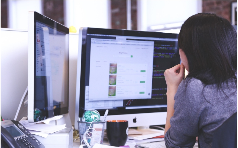 모니터 2대 앞에서 일하는 여성 모습