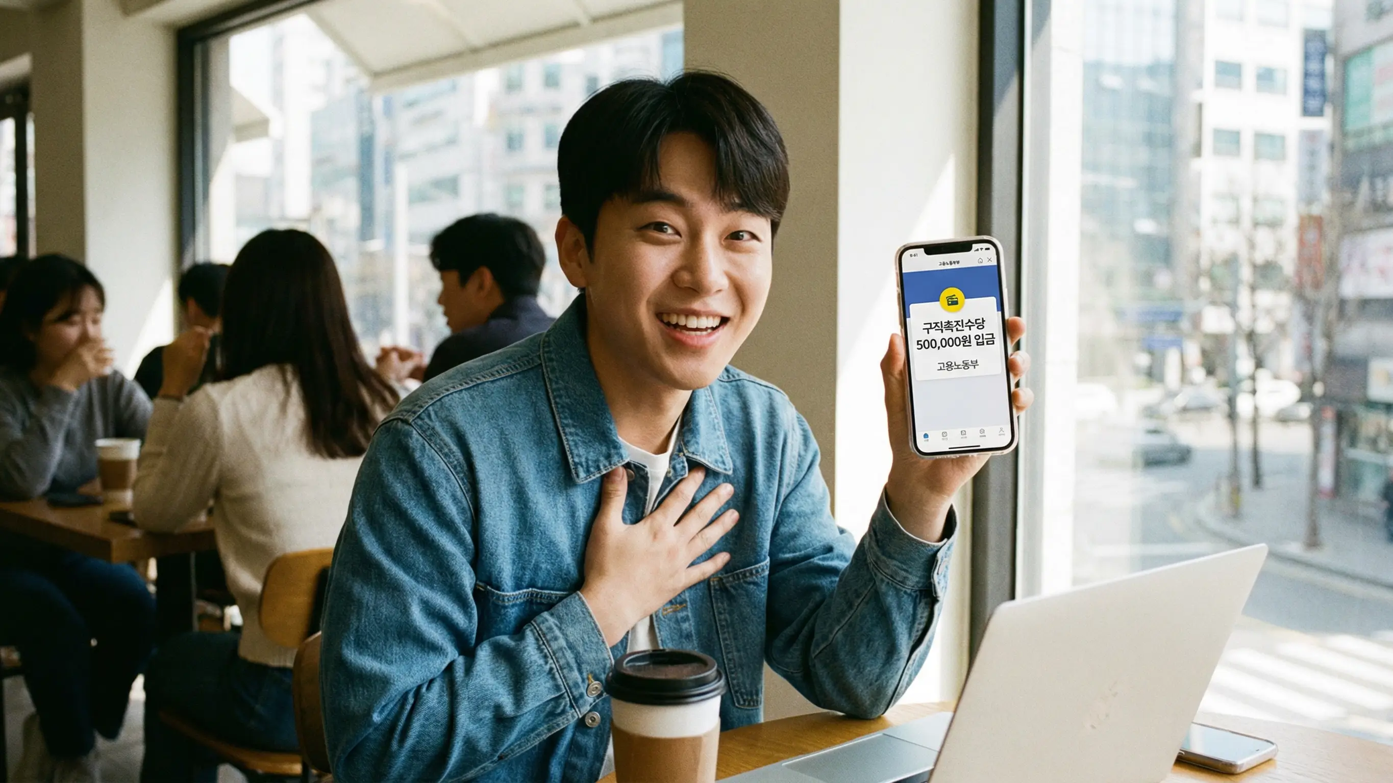 카페에서 스마트폰으로 구직촉진수당 50만원 입금 내역을 확인하고 기뻐하는 청년의 모습