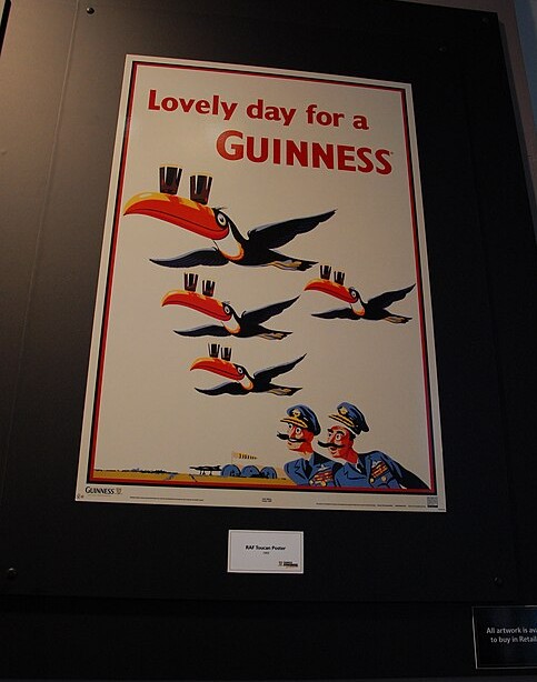 기네스 스토어하우스에 전시된 ‘Lovely day for a Guinness’ 빈티지 광고 포스터와 기네스 잔을 부리에 올린 큰부리새 일러스트
