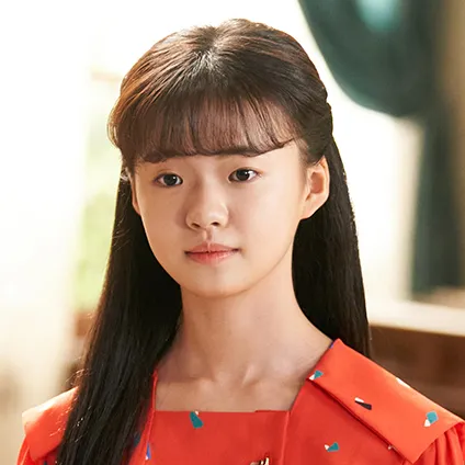 어느 실내를 배경으로 빨강 원피스를 입고 긴머리를 단정하게 내려트린 12살 윤주원