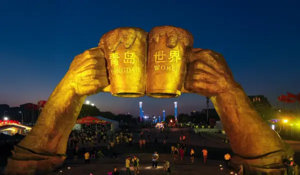 금사탄-맥주-상가에-위치한-건배하는-손과-칭다오-맥주-잔-모형