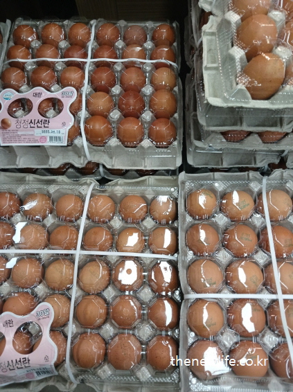 투명 포장된 계란 30구 단위 상품들이 쌓여 있는 마트 진열대