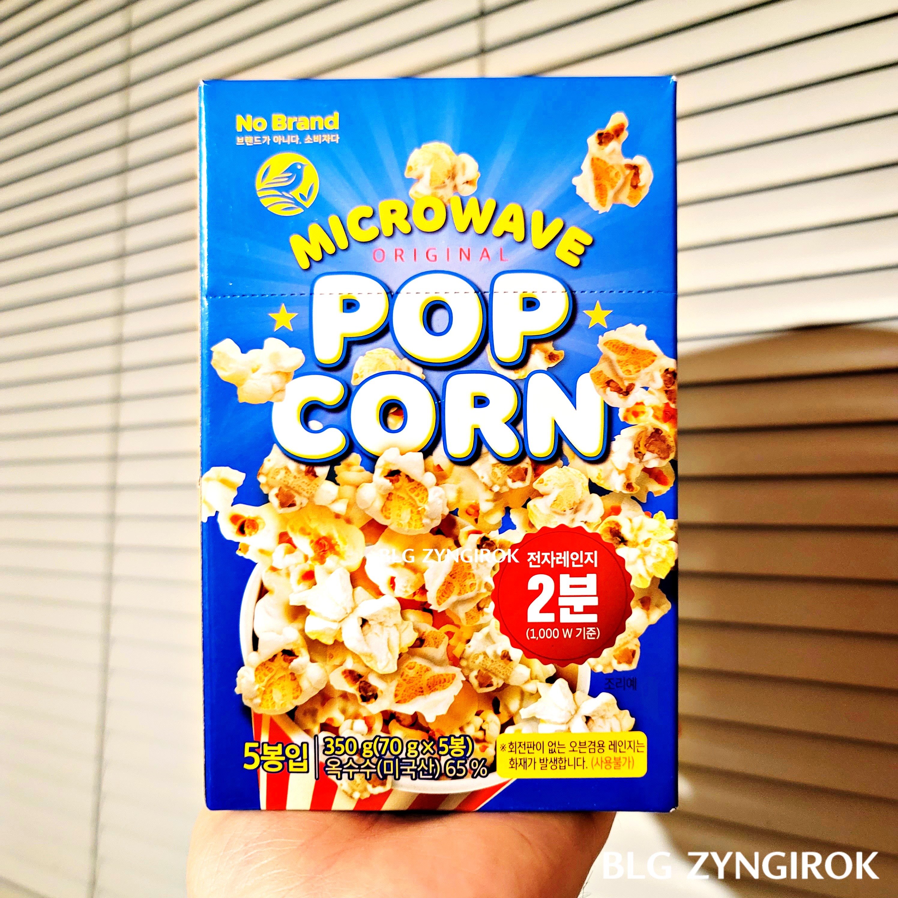 노브랜드 팝콘 상자를 들고 있다.