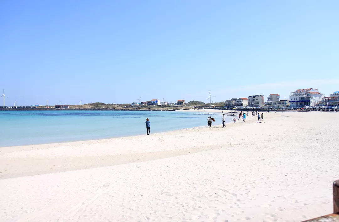 제주 올레길 20코스 초반부에 만나는 김녕해수욕장의 이국적인 흰 모래사장과 에메랄드빛 바다 풍경 사진.