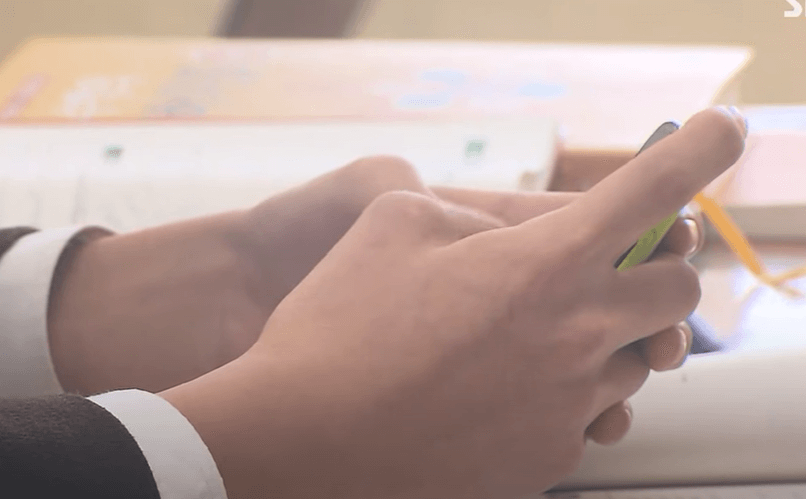 학생이 교실에서 휴대전화를 사용하는 장면