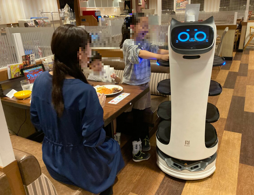 로봇에게 음식을 전달 받는 손님