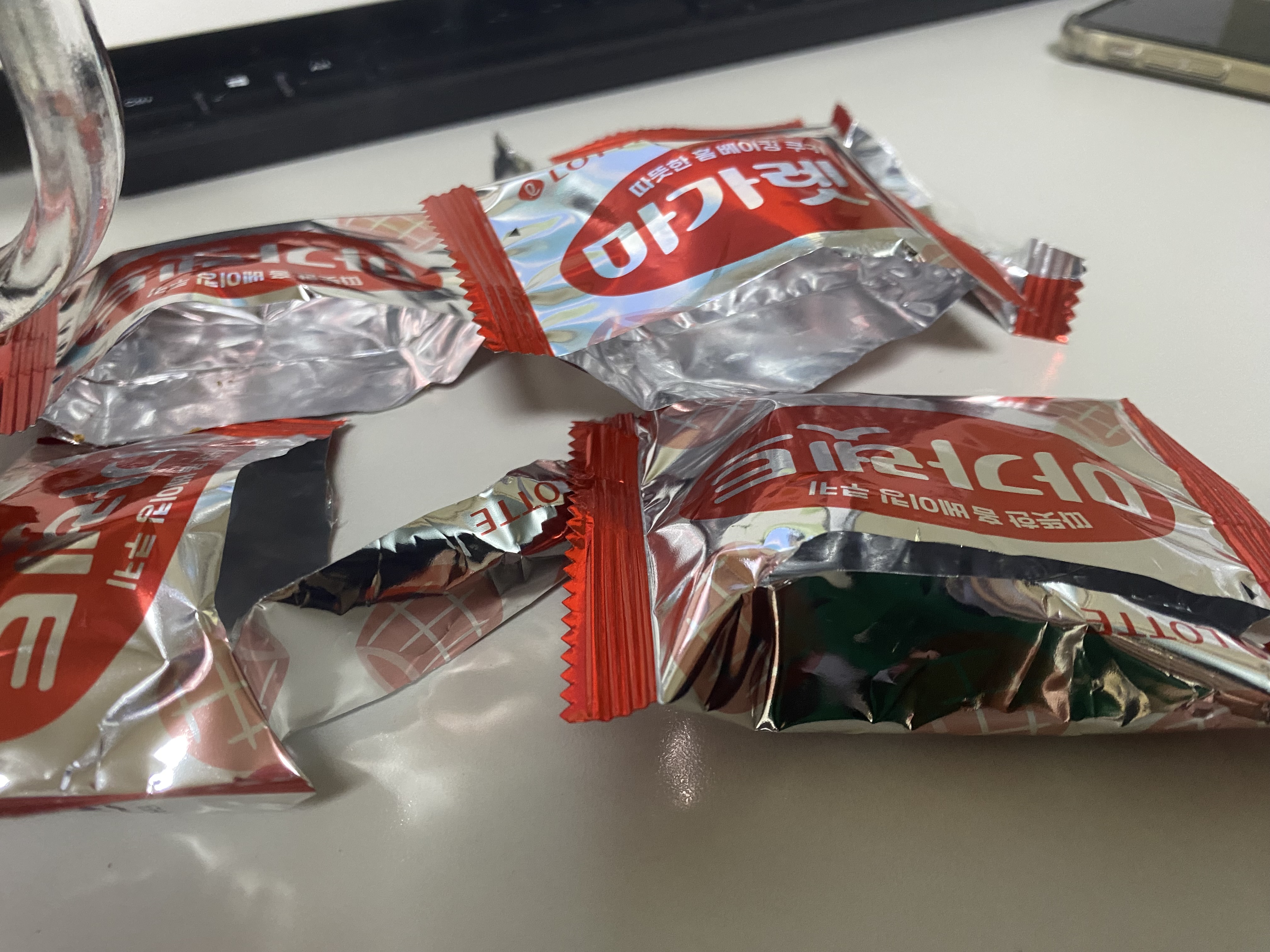 흰색 책상위에 마가렛트를 다 먹은 포장지 4개가 있는 사진입니다.