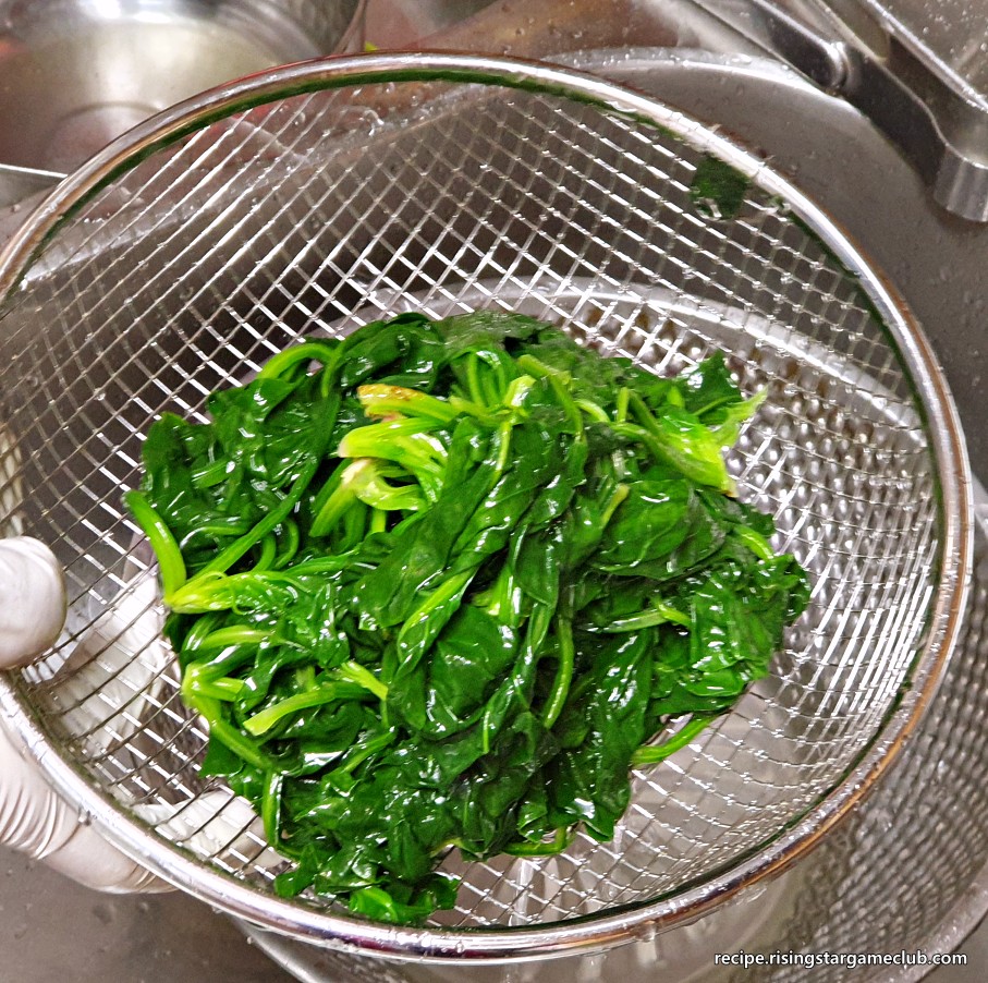 시금치나물 무침을 하기 위해서 찬물에 씻은 데쳐진 시금치를 채반에 건져 놓은 사진
