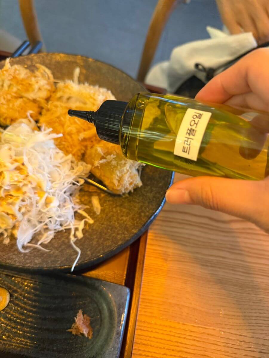 치즈카츠 위에 카츠쇼신 트러플오일을 뿌리는 모습
