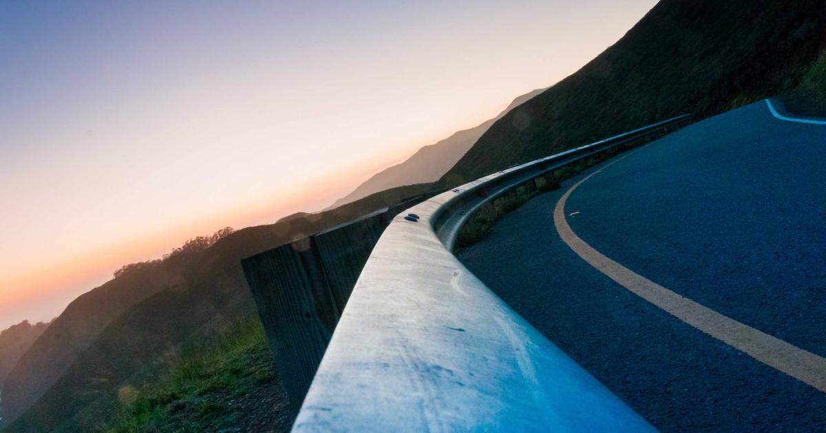 young person enthusiastically checking financial app on smartphone, charts and graphs in background, bright and modern