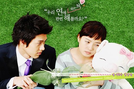 남녀 두 주인공이 소품을 안고 있는 사진