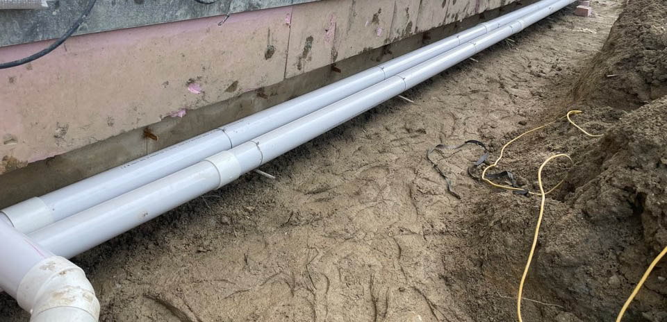 오수 배관의 정확한 경사(구배) 유지를 위해 벽돌 대신 철근 팩을 기초에 박아 배관을 견고하게 고정한 시공 현장 사진