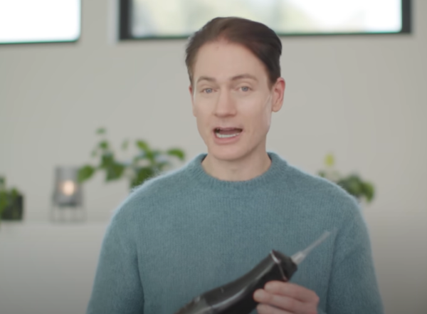 브라이언 존슨이 자신의 치아관리를 위해 쓰는 워터픽을 들고 있는 모습