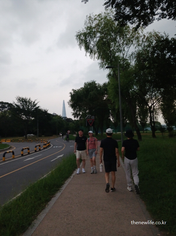 낮 시간 잠실 한강공원 산책로를 걷는 사람들