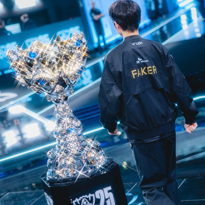 e스포츠 전설 페이커 선수가 롤드컵 우승컵 옆에 서 있는 모습